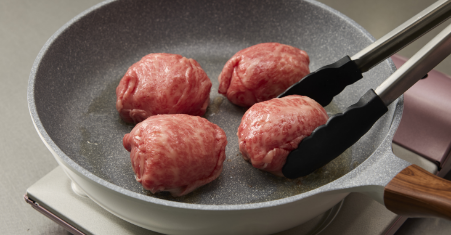 牛肉の肉巻きおにぎりの作り方　3.フライパンに油を入れて熱し、②を入れて転がしながら全面に焼き目をつけます。