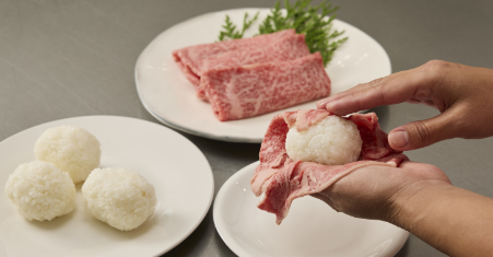 牛肉の肉巻きおにぎりの作り方　2.ごはんを適量丸めて、鹿児島県和牛で巻きます。